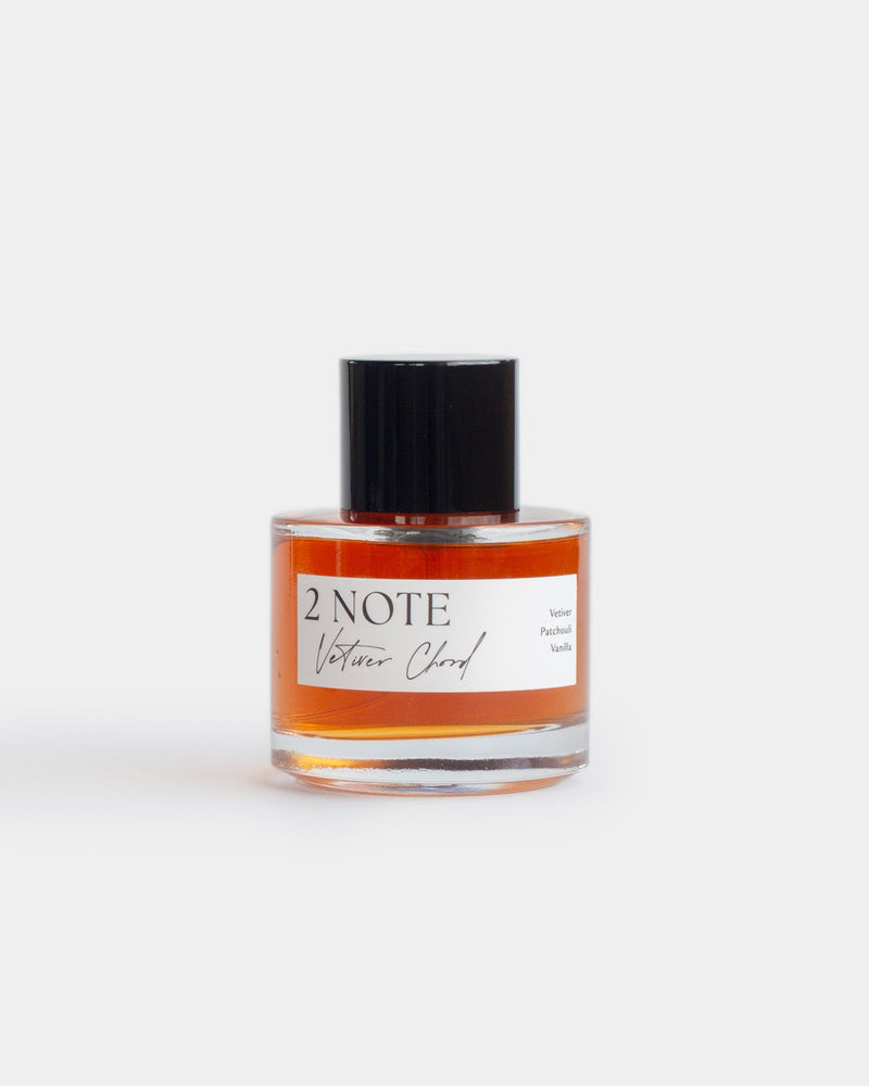 Vetiver Chord in clear glass spray bottle — single-note botanical fragrance, deep amber oil, front view on white