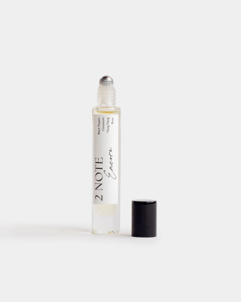 Encore in tall clear glass roller bottle — botanical fragrance oil, pale straw, uncapped
