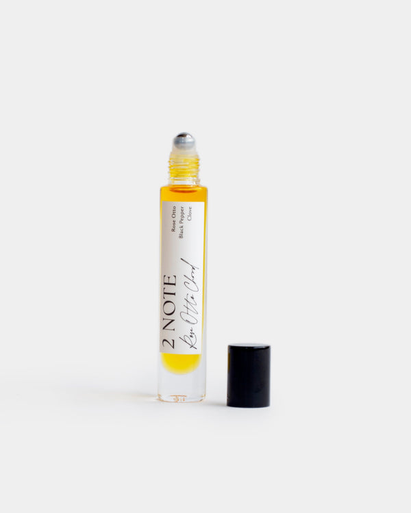 Rose Otto Chord in tall clear glass roller bottle — botanical natural fragrance oil, golden yellow, uncapped