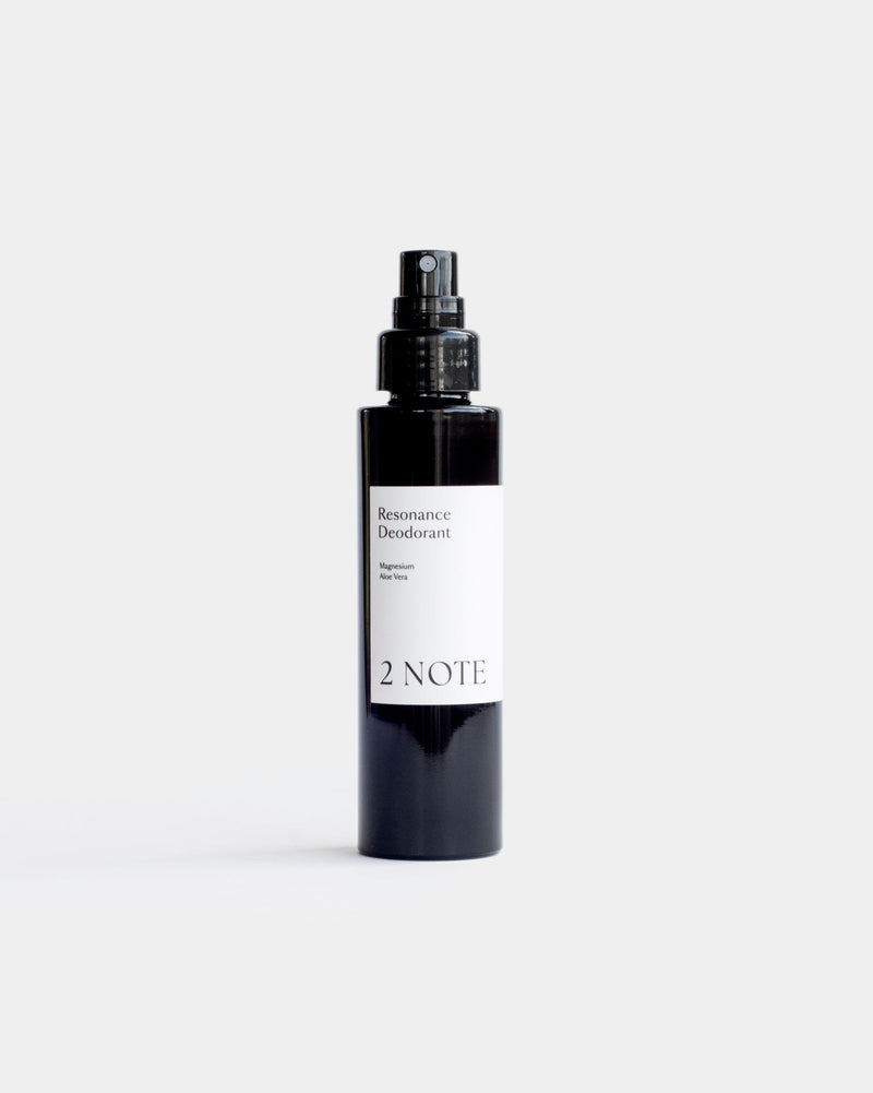Resonance Deodorant in matte black fine-mist spray bottle — botanical natural skincare deodorant with Bergamot, Clary Sage, and Geranium, front view on light gray
