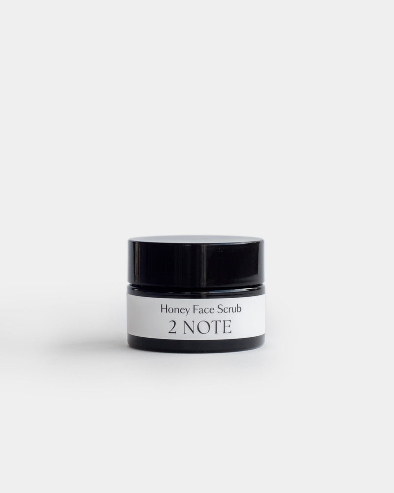 Honey Face Scrub in small squat matte black jar — botanical natural skincare exfoliator, lid closed, front view on white