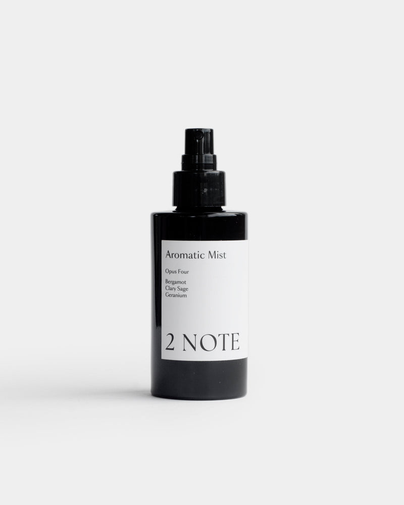 Aromatic Mist in matte black fine-mist spray bottle — botanical fragrance room and body mist with Bergamot, Clary Sage, and Geranium, front view on light gray