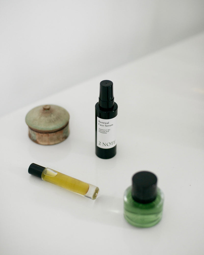 Renewal Face Serum matte black bottle styled in natural skincare editorial arrangement