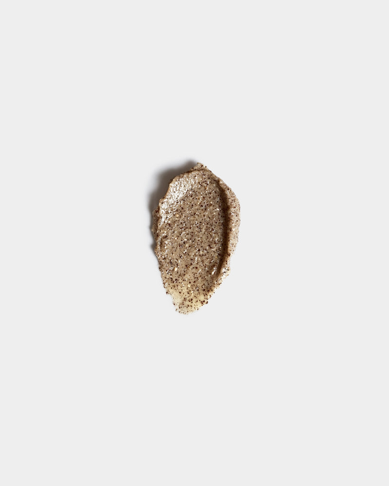 Honey Face Scrub formula swatch — golden-brown granular exfoliant smear with visible botanical particles on white surface