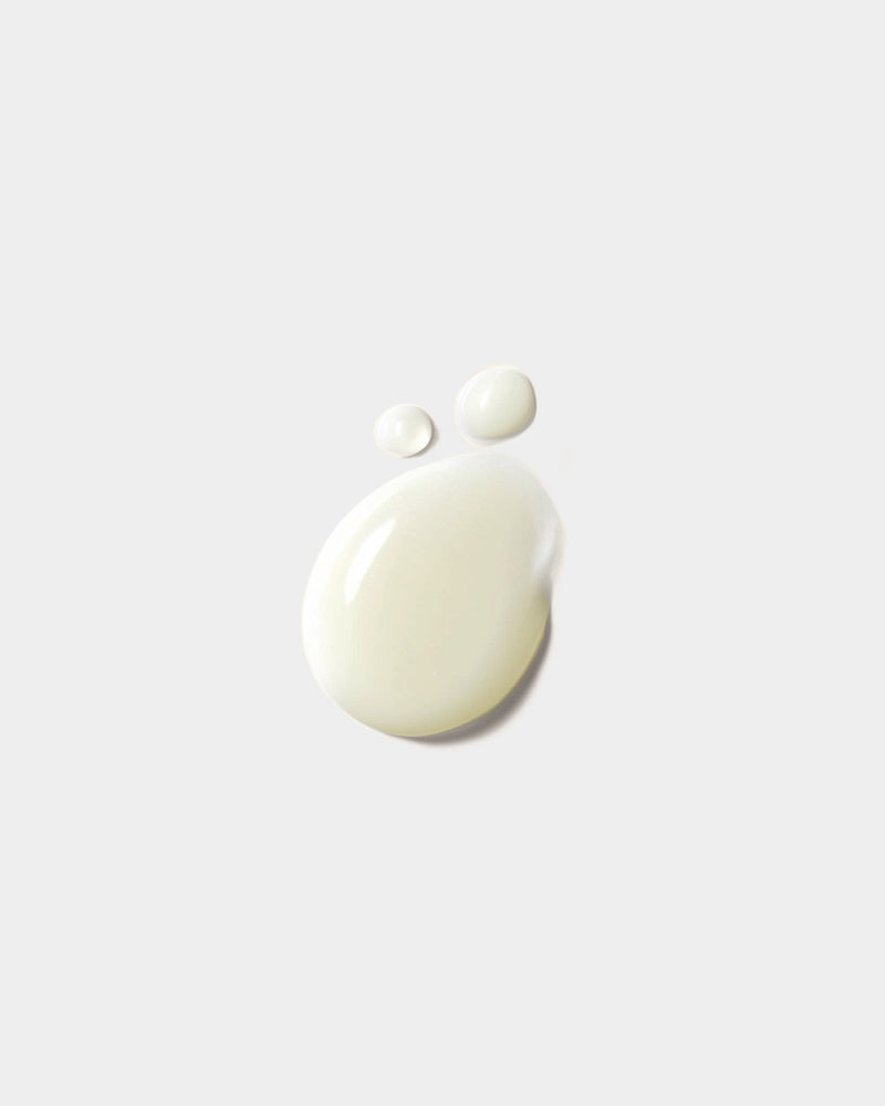 Shower Gel formula swatch — off-white botanical gel drops on light gray surface, natural skincare texture