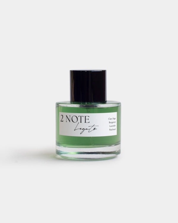 Legato in clear glass spray bottle — botanical natural fragrance, vivid emerald green oil, front view on white