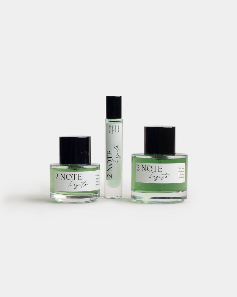 Legato botanical fragrance in three sizes — small and large spray bottles and a roller, emerald green oil through clear glass