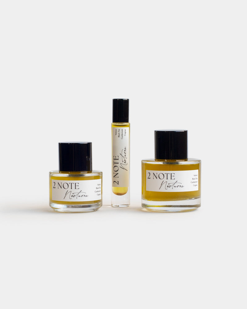 Nocturne botanical fragrance in three sizes — small and large spray bottles and a roller, golden amber oil through clear glass