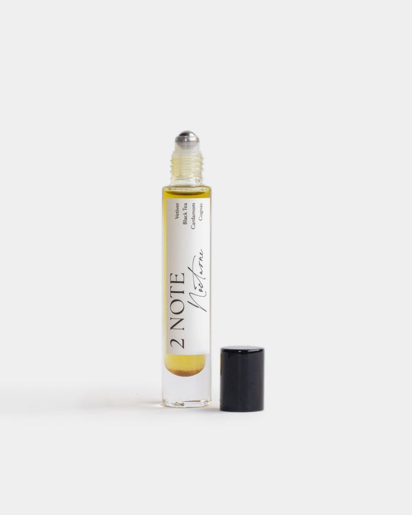 Nocturne in tall clear glass roller bottle — botanical fragrance oil, golden amber, uncapped