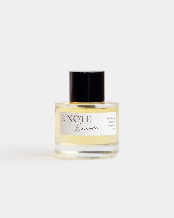 Encore in clear glass spray bottle — botanical natural fragrance, pale straw oil, front view on white