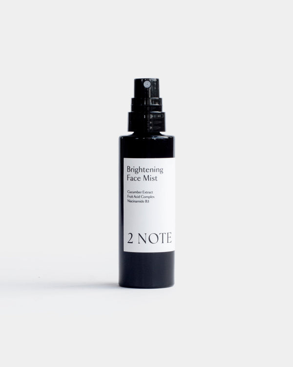Brightening Face Mist in matte black spray bottle — botanical natural skincare with Cucumber Extract, Fruit Acid Complex, and Niacinamide B3, front view on white