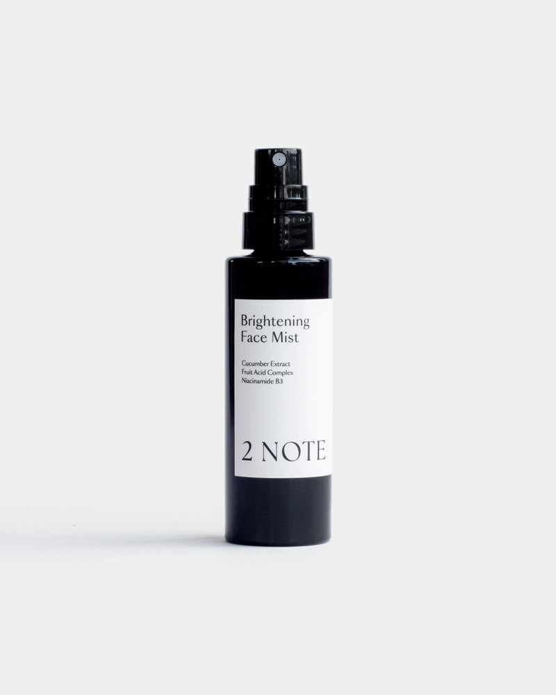 Brightening Face Mist in matte black spray bottle — botanical natural skincare with Cucumber Extract, Fruit Acid Complex, and Niacinamide B3, front view on white
