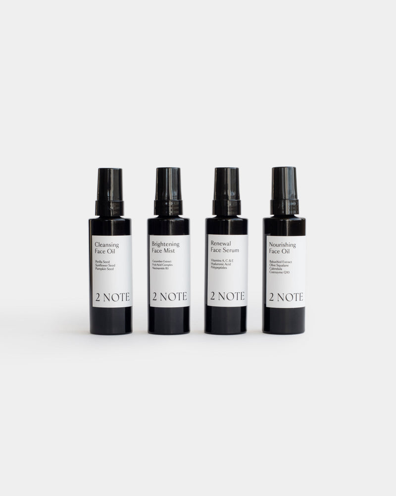 Brightening Face Mist matte black bottle styled in botanical natural skincare editorial, close-up detail
