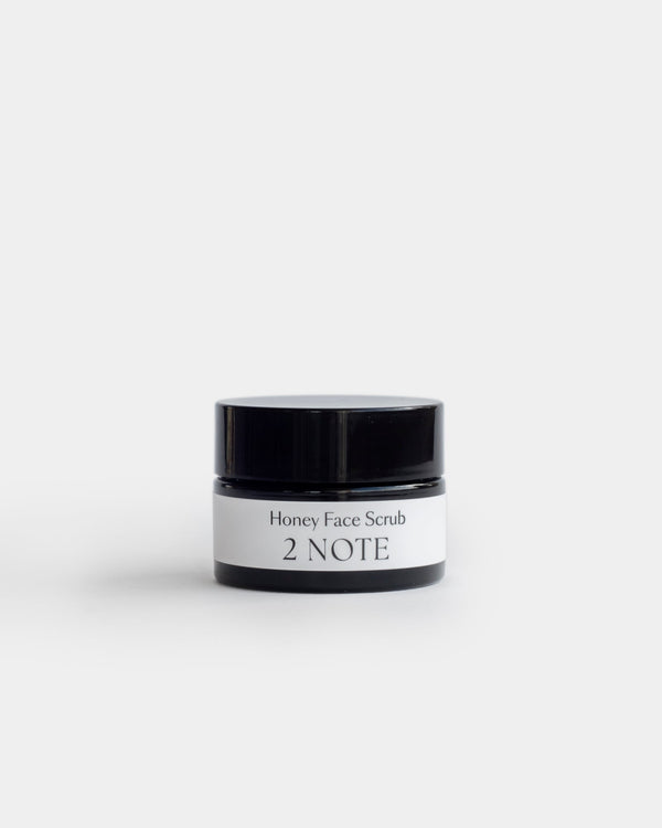 Honey Face Scrub in small squat matte black jar — botanical natural skincare exfoliator, lid closed, front view on white