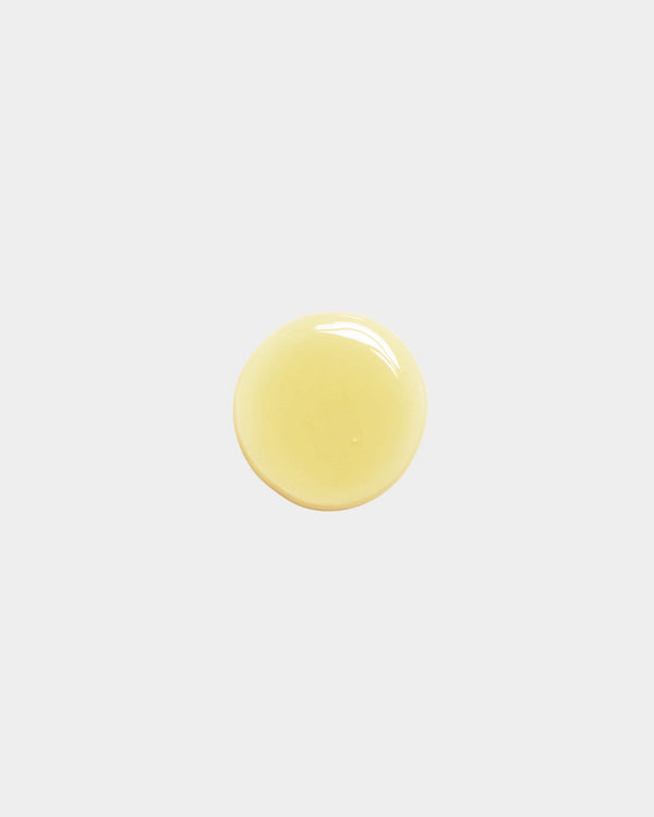 Cleansing Face Oil formula swatch — single pale yellow botanical oil drop on white surface