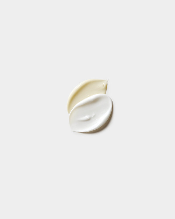 Hand Duo Set formula swatches — pale yellow and white cream drops overlapping on light gray, botanical natural skincare soap and lotion texture pair